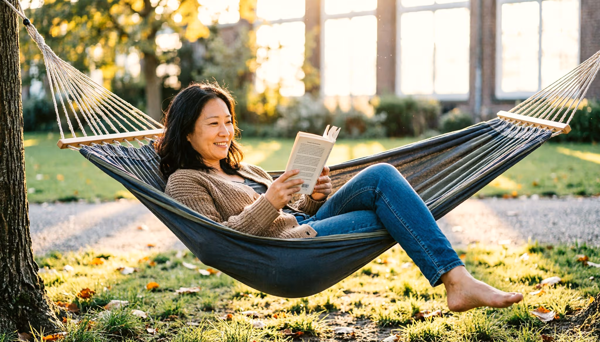 Een vrouw ontspant met een boek in een hangmat in een Nederlands stadspark in het late middaglicht